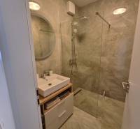 Badezimmer mit Dusche und Waschbecken in einer 3-Zimmer-Wohnung.