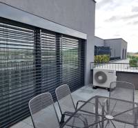 Terrasse einer 3-Zimmer-Wohnung in der Pieskova-Straße in Nitra mit Außenbereich und Jalousien.