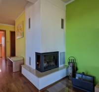 Ferienwohnung mit grüner Wand, Kamin und Holzboden.