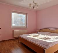 Schlafzimmer in einer Ferienwohnung mit Holzboden, rosa Wänden und einem Bett.