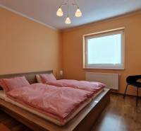 Schlafzimmer mit Doppelbett und Holzmöbeln im Ferienapartment.