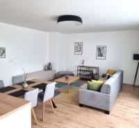 Wohnzimmer in einer 3-Zimmer-Wohnung mit Esstisch, Sofa und Dekorationen.