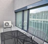Balkon in einer 3-Zimmer-Wohnung mit Metallmöbeln und Klimaanlage.