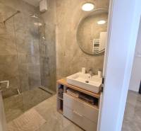 Badezimmer in einer 3-Zimmer-Wohnung mit Duschkabine und Waschtischunterschrank.