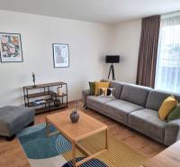 Wohnzimmer mit einem bequemen grauen Sofa und bunten Kissen in einer 3-Zimmer-Wohnung.