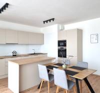 Küche in einer 3-Zimmer-Wohnung mit Holztisch und modernen Geräten.