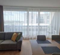 Wohnzimmer einer 3-Zimmer-Wohnung mit Sofa, Esstisch und Blick auf den Balkon.
