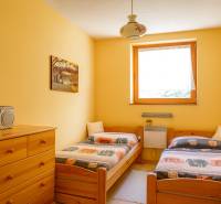 Ein Doppelzimmer in einer Hütte mit Holzmöbeln und einem Radio auf der Kommode.