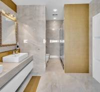 Luxuriöses Badezimmer mit Doppelwaschbecken und goldenen Details in einer 4-Zimmer-Wohnung.