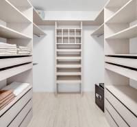 Ein Kleiderschrank mit hellen Regalen und Stauraum in einer 4-Zimmer-Wohnung.