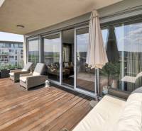 Die Terrasse einer 4-Zimmer-Wohnung in Bratislava - Karlova Ves mit bequemen Liegestühlen und einem Sofa.