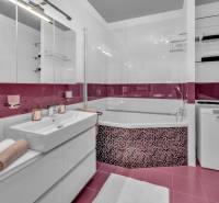 Badezimmer mit Dusche, Schrank und Waschmaschine in einer 4-Zimmer-Wohnung.