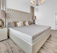 Luxuriöses Schlafzimmer mit großem Bett und stilvollem Kronleuchter in einer 4-Zimmer-Wohnung.