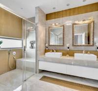 Luxuriöses Badezimmer mit zwei Waschbecken, Spiegeln und einer Duschkabine in einer 4-Zimmer-Wohnung.