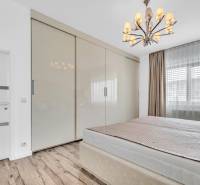 Schlafzimmer mit Kleiderschrank und Kronleuchter in einer 4-Zimmer-Wohnung.