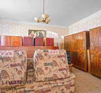 Ein Zimmer in einem Einfamilienhaus mit antiken Möbeln und dekorativen Tapeten.