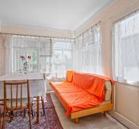 Innenraum eines Einfamilienhauses mit Sofa, Esstisch und Blumendekoration in einer Vase.