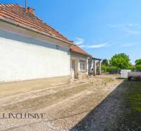 Höfe eines Einfamilienhauses in Jahodná mit Anhänger, Tank und Grünflächen.