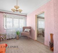 Ein Zimmer in einem Einfamilienhaus mit Tapeten, einem Sessel und Blumendekoration.