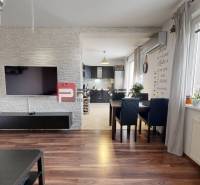 Wohnzimmer in einer 2-Zimmer-Wohnung mit einem Fernseher an der Wand und einem Esstisch.