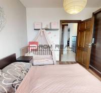 Schlafzimmer in einer 2-Zimmer-Wohnung mit Kinderbett, Spiegelschrank und Wanddekoration.