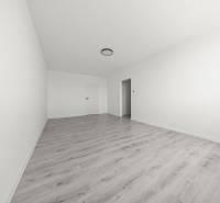 Geräumiges Zimmer mit Laminatboden und weißen Wänden in einer 2-Zimmer-Wohnung.