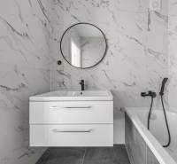 Badezimmer mit Marmorboden und Badewanne in einer 2-Zimmer-Wohnung.