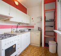 Küche in einer 2-Zimmer-Wohnung mit weißen Schränken und einem Gasherd.