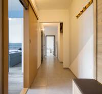 Ein Flur mit hellen Wänden, Einbauschränken und Haken in einer 2-Zimmer-Wohnung.
