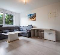 Wohnzimmer mit Ecksofa und Holzmöbeln in einer 2-Zimmer-Wohnung.