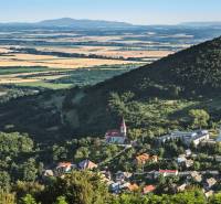 Panoramablick auf ein Dorf im Tal, umgeben von Wäldern und Feldern. Grundstücke geeignet zum Wohnen.
