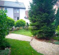 Ein schöner Garten mit einem Weg bei einem Einfamilienhaus in Nováky, umgeben von Grün und Bäumen.