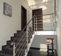 Eine Treppe mit modernem Geländer führt zu den Türen in einer 2-Zimmer-Wohnung.