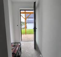 Der Flur im Einfamilienhaus mit offenen Türen, Blick nach draußen auf den Garten.