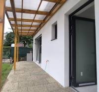 Die Terrasse des Einfamilienhauses in Malé Kršteňany mit einem Dachüberstand und Zugang zum Garten.