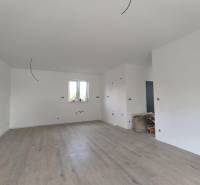 Innenraum eines Einfamilienhauses mit Holzboden, weißen Wänden und Vorbereitung für Elektroinstallation.