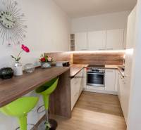 Küche mit Bartisch, grünen Stühlen und Dekorationen in einer 3-Zimmer-Wohnung.