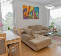 Wohnzimmer mit beigem Sofa, Esstisch und buntem Bild in einer 3-Zimmer-Wohnung.