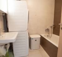 Badezimmer mit Badewanne, Waschbecken, Waschmaschine in einer 3-Zimmer-Wohnung.