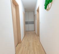 Ein heller Flur mit Holzboden und mehreren weißen Türen in einer 3-Zimmer-Wohnung.