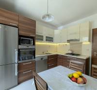 Küche in einer 4-Zimmer-Wohnung mit Holzschränken und Edelstahlgeräten.