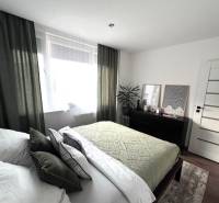 Schlafzimmer in einer 4-Zimmer-Wohnung mit stilvollem Dekor und Möbeln.