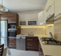 Küche in einer 4-Zimmer-Wohnung mit Holzschränken, Herd und Kühlschrank.