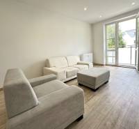 Helles Wohnzimmer in einer 2-Zimmer-Wohnung mit Sofa und großem Fenster.