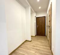 Der Flur in der 2-Zimmer-Wohnung mit Holzboden und weißen Wänden.