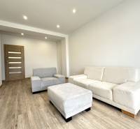 Helles Wohnzimmer in einer 2-Zimmer-Wohnung mit beigen Möbeln und Holzboden.