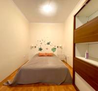 Schlafzimmer in einer 3-Zimmer-Wohnung mit einem Kleiderschrank und Wanddekorationen.