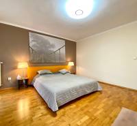 Schlafzimmer in einer 3-Zimmer-Wohnung mit Holzboden und einem großen Bild von einer Brücke.