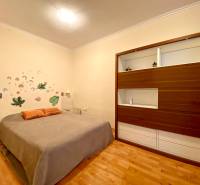 Schlafzimmer mit Bett, Wanddekoration und Einbauschrank in einer 3-Zimmer-Wohnung.