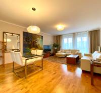 Wohnzimmer in einer 3-Zimmer-Wohnung mit Holzboden, bequemer Couch und Esstisch.